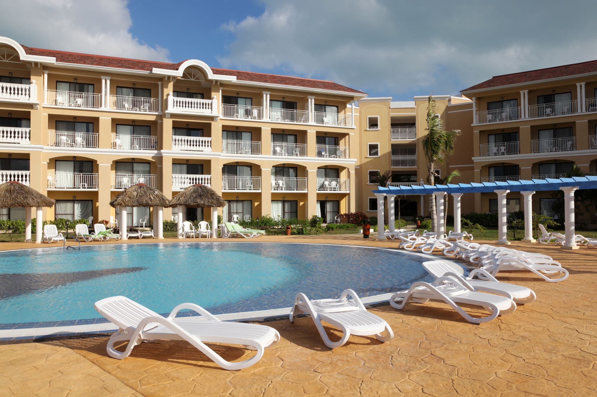 Commercial pool at a hotel property with beach chairs.